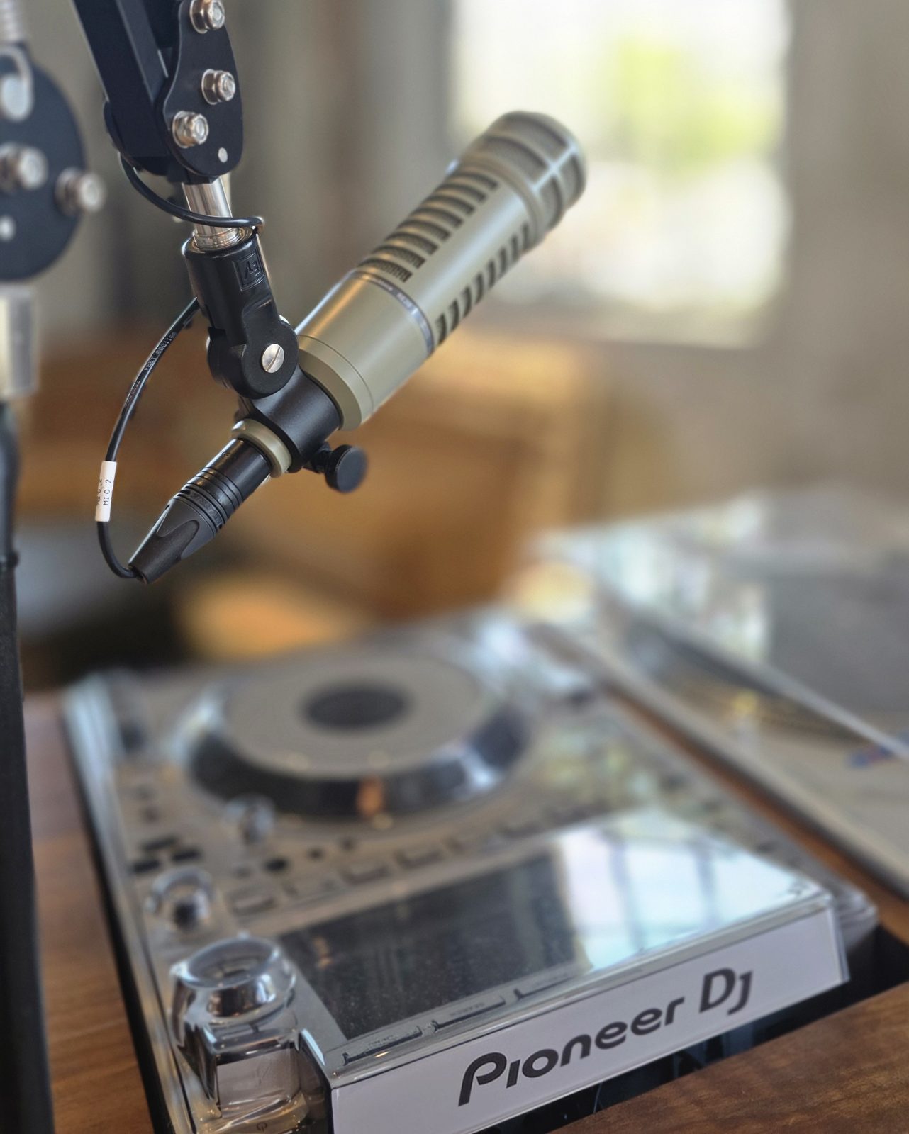 Broadcast microphone on a boom arm above a DJ deck